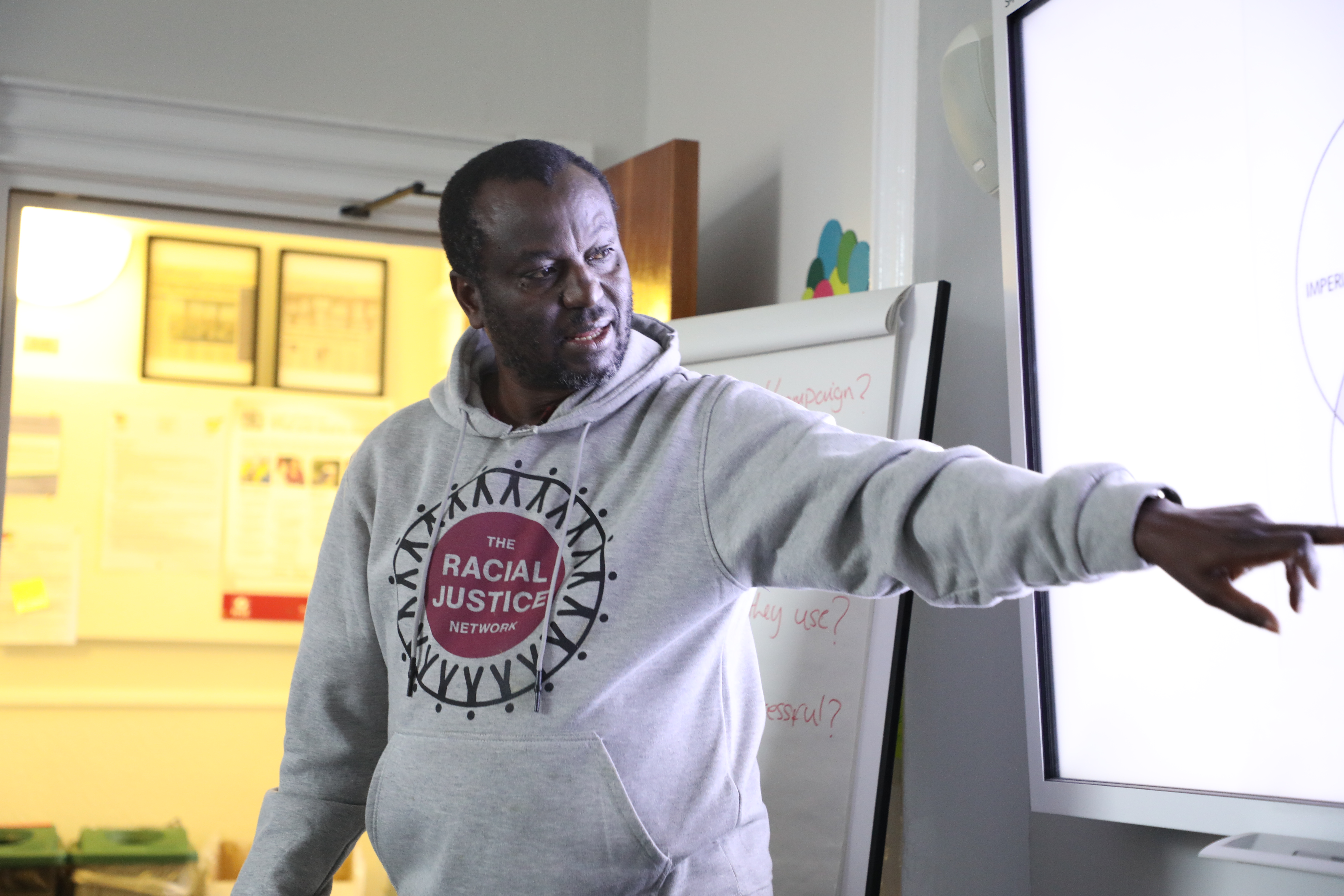 Facilitator in RJN hoodie at whiteboard
